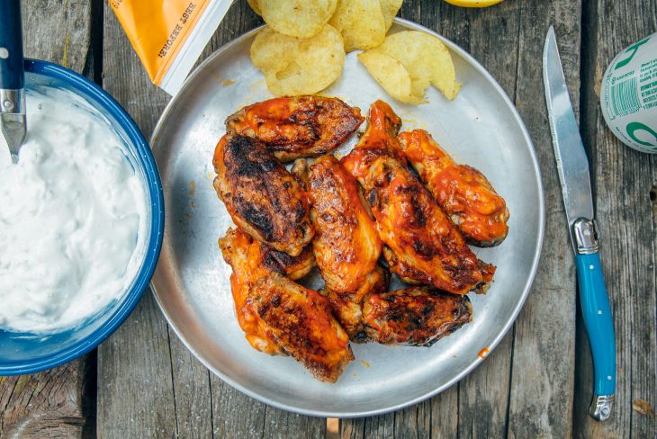 Grilled buffalo wings on a plate with potato chips
