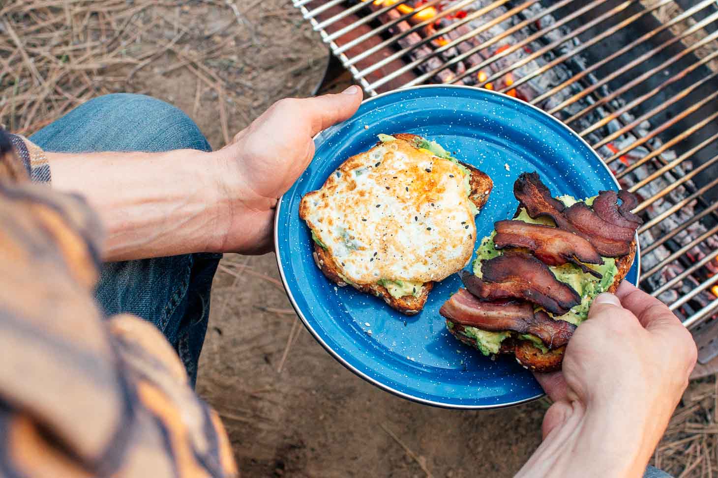 Michael holding a blue plate with a fried egg and bacon on toast