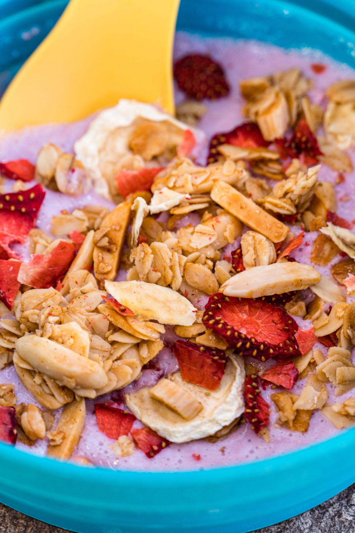 Close up of yogurt, granola, and fruit in a blue bowl