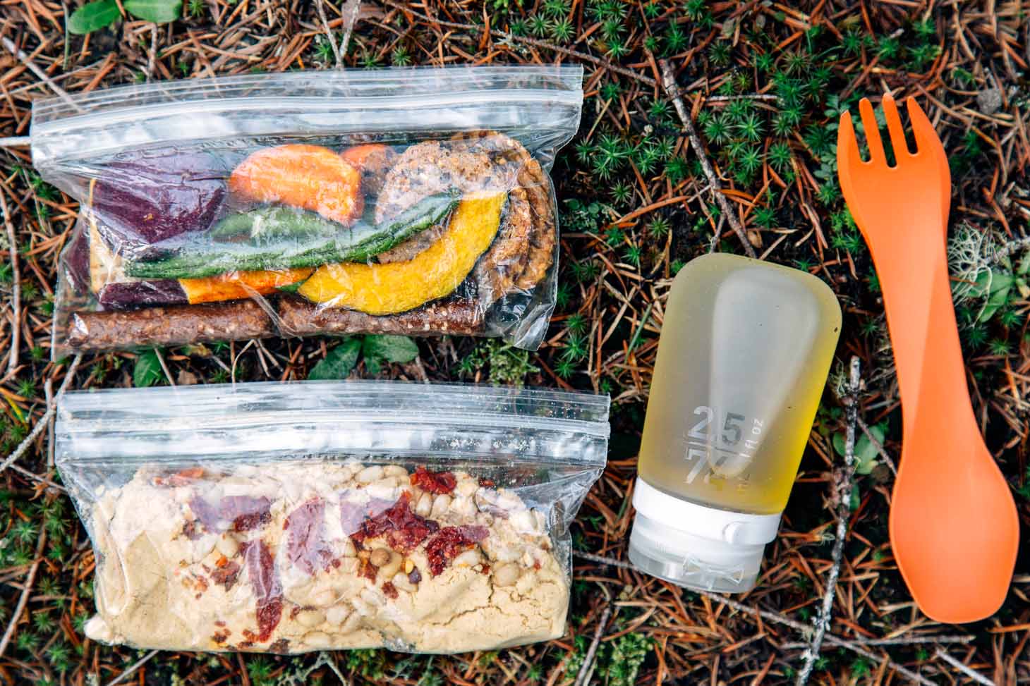 Ingredients for backpacking hummus in ziplock bags on a forest floor.