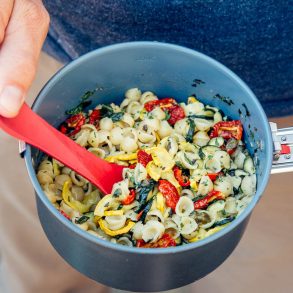 Michael holding a backpacking pot filled with pasta