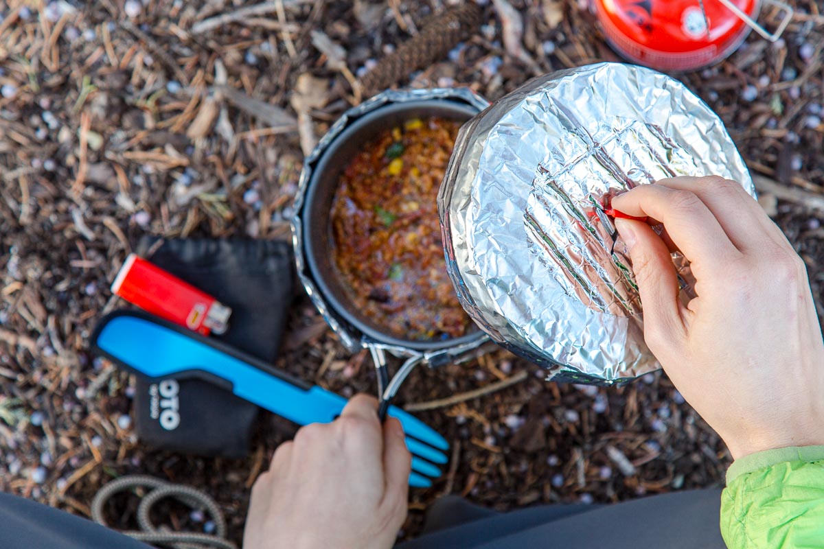 Megan placing the lid on a pot inside a cozy