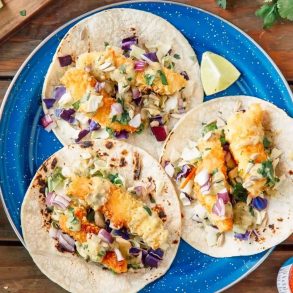 Three fish tacos on a blue plate