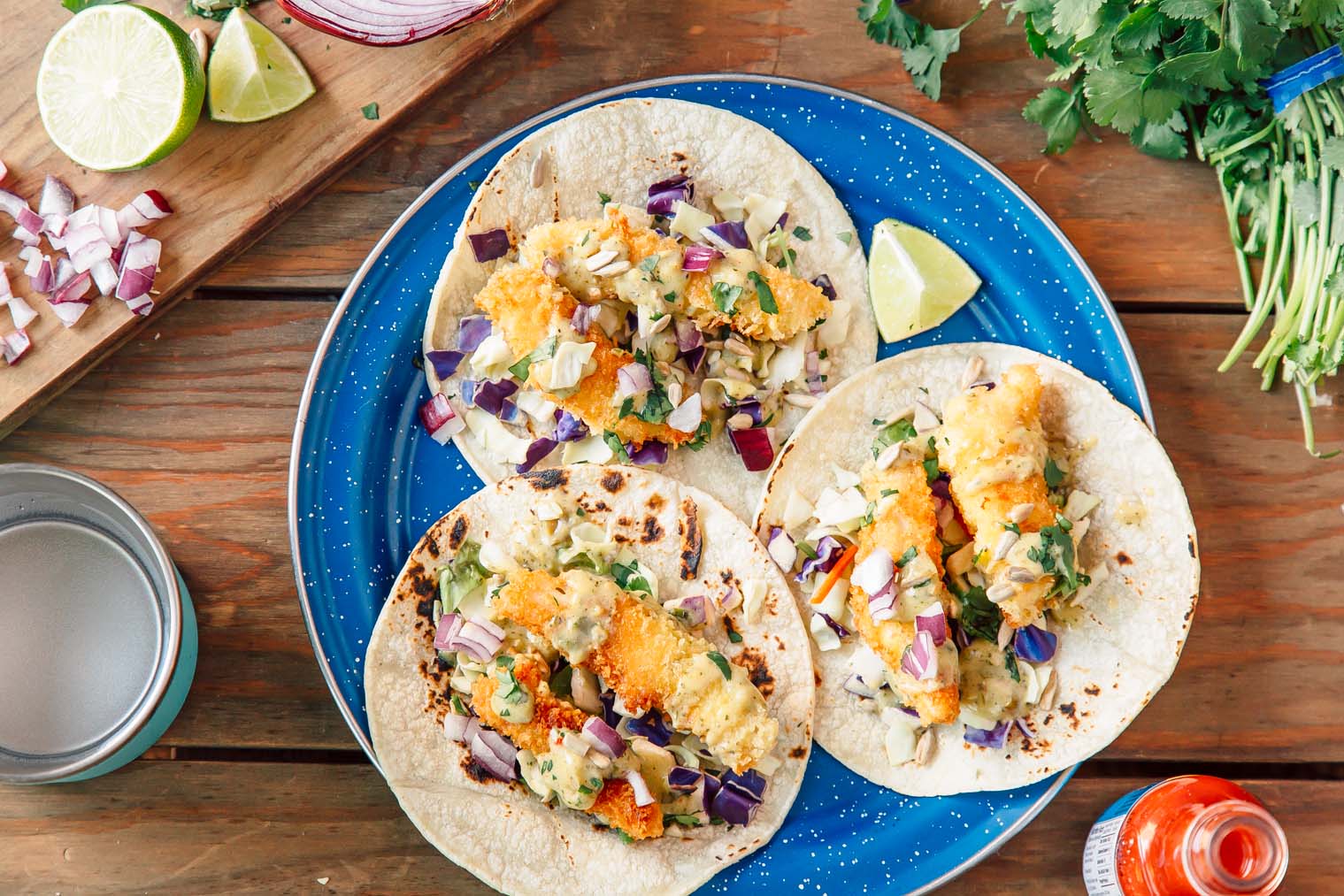 Three Baja style fish tacos on a blue camping plate