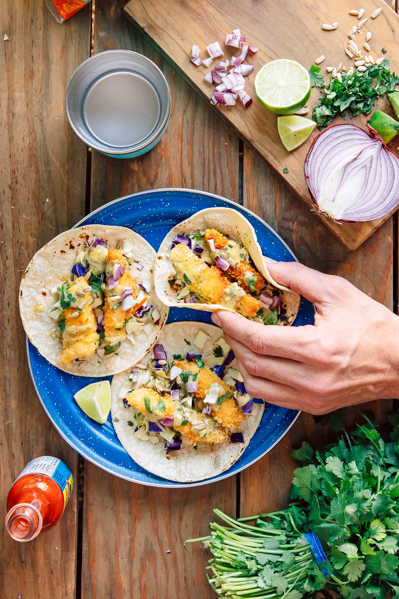 Michael picking up one of three tacos on a blue camping plate