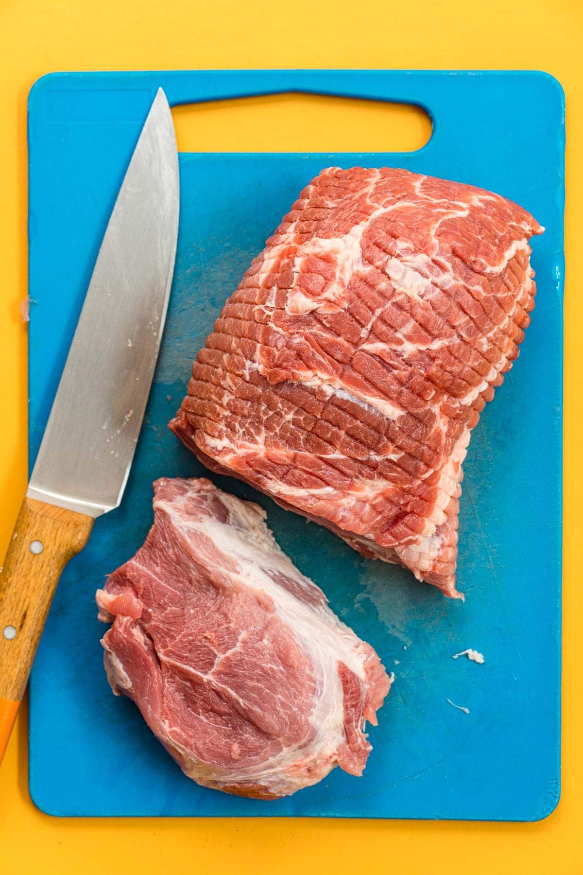 Pork shoulder on a blue cutting board.