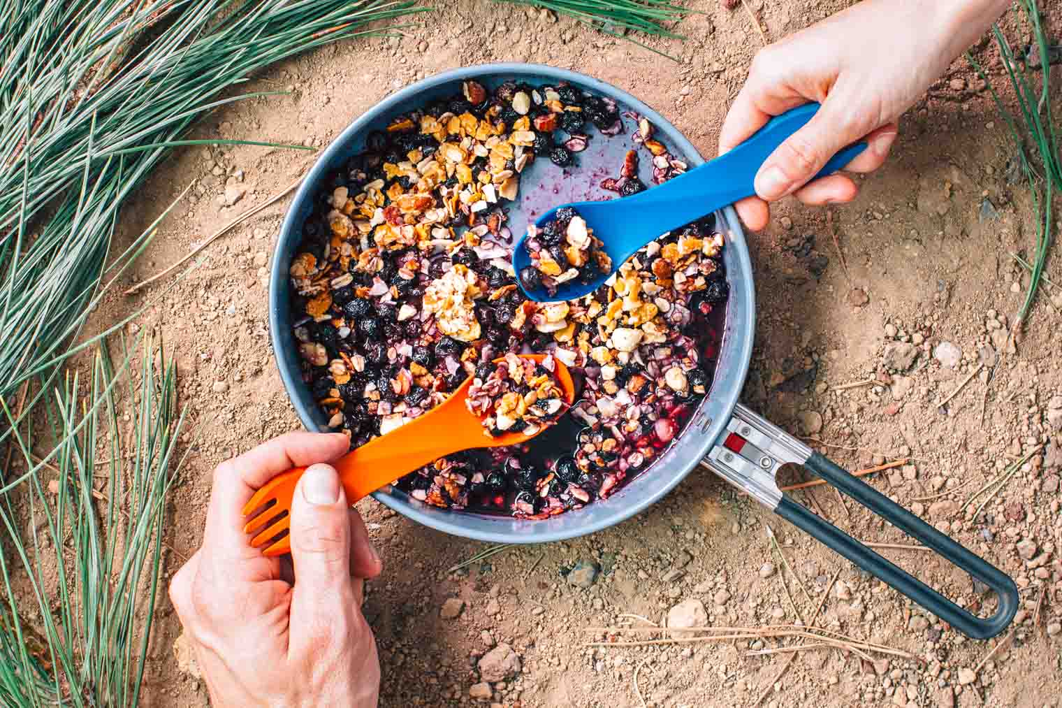 Michael and Megan taking spoonfuls of berry cobbler out of a skillet