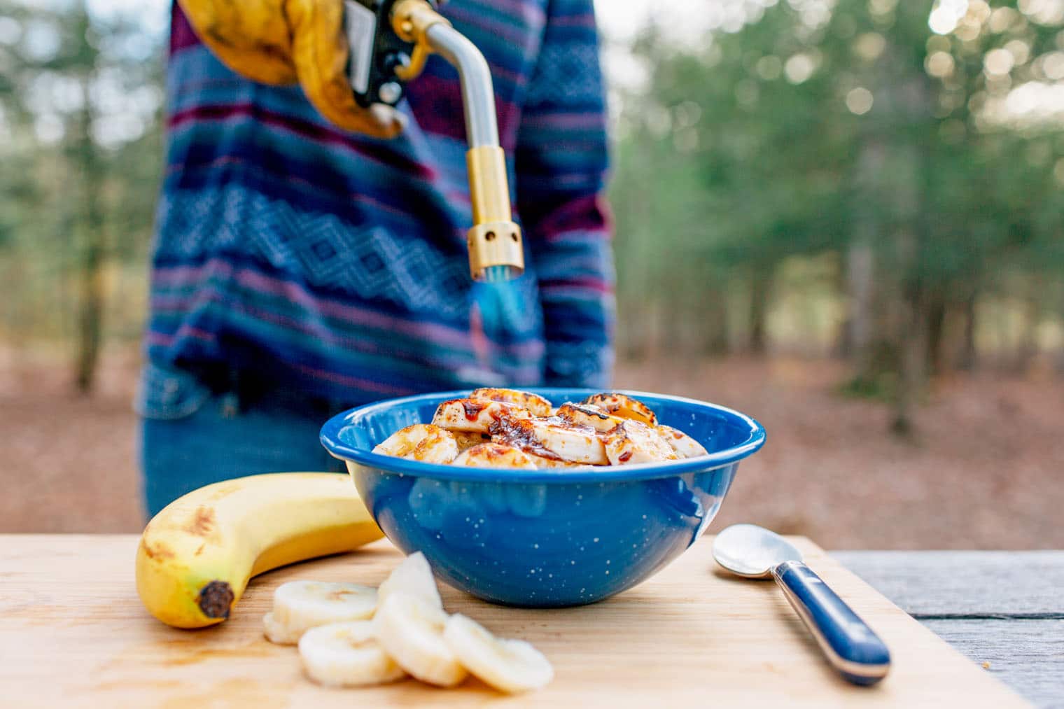 Megan using a camping torch to Brulé bananas