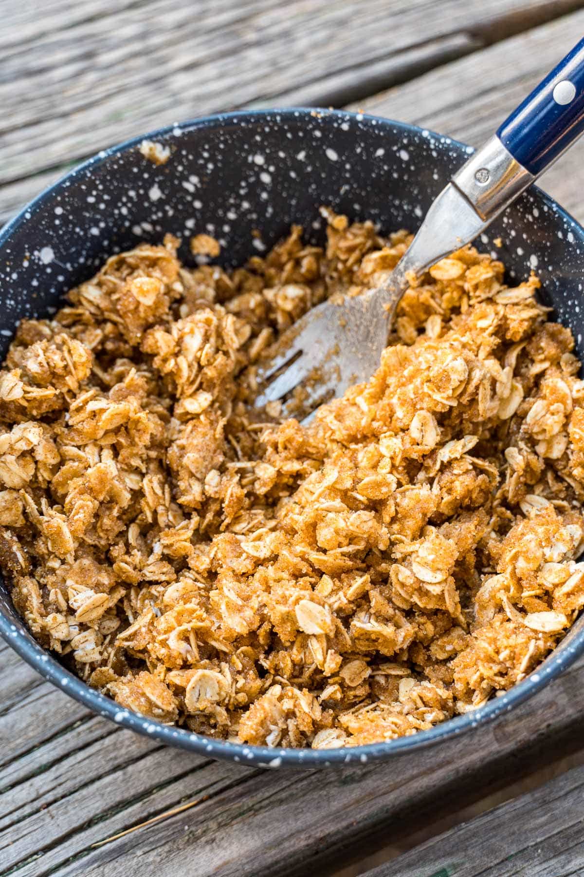 Oats mixed with sugar, spices, and butter in a bowl.