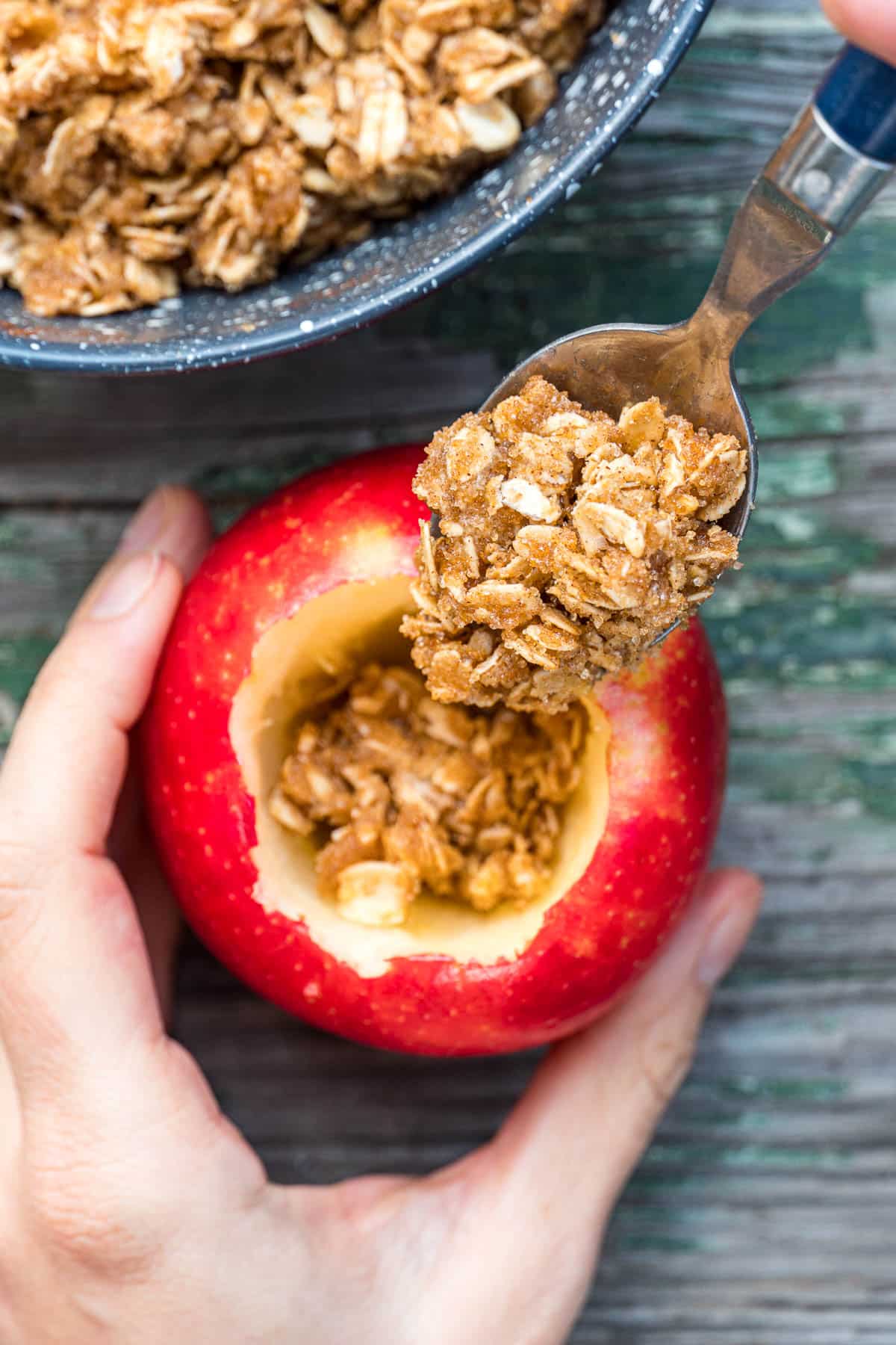 Filling an apple with oat mixture.