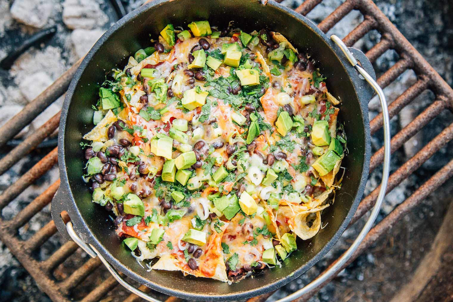 Nachos in a Dutch oven on a campfire grill grate