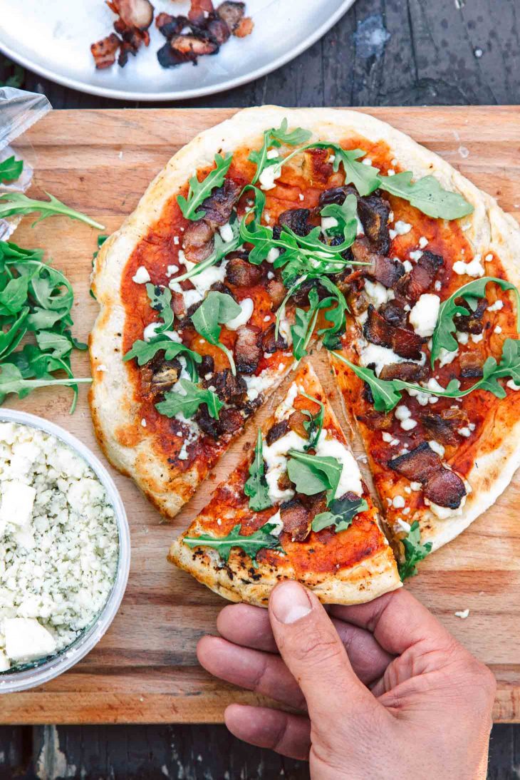 Campfire pizza on a wooden board.