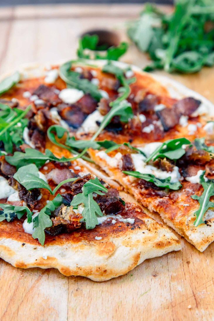 Campfire pizza on a wooden board.