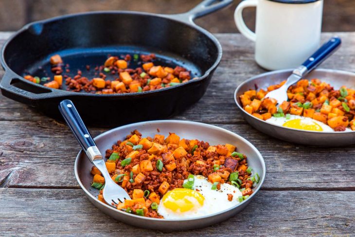 Sweet potato and chorizo hash with an egg on a plate.