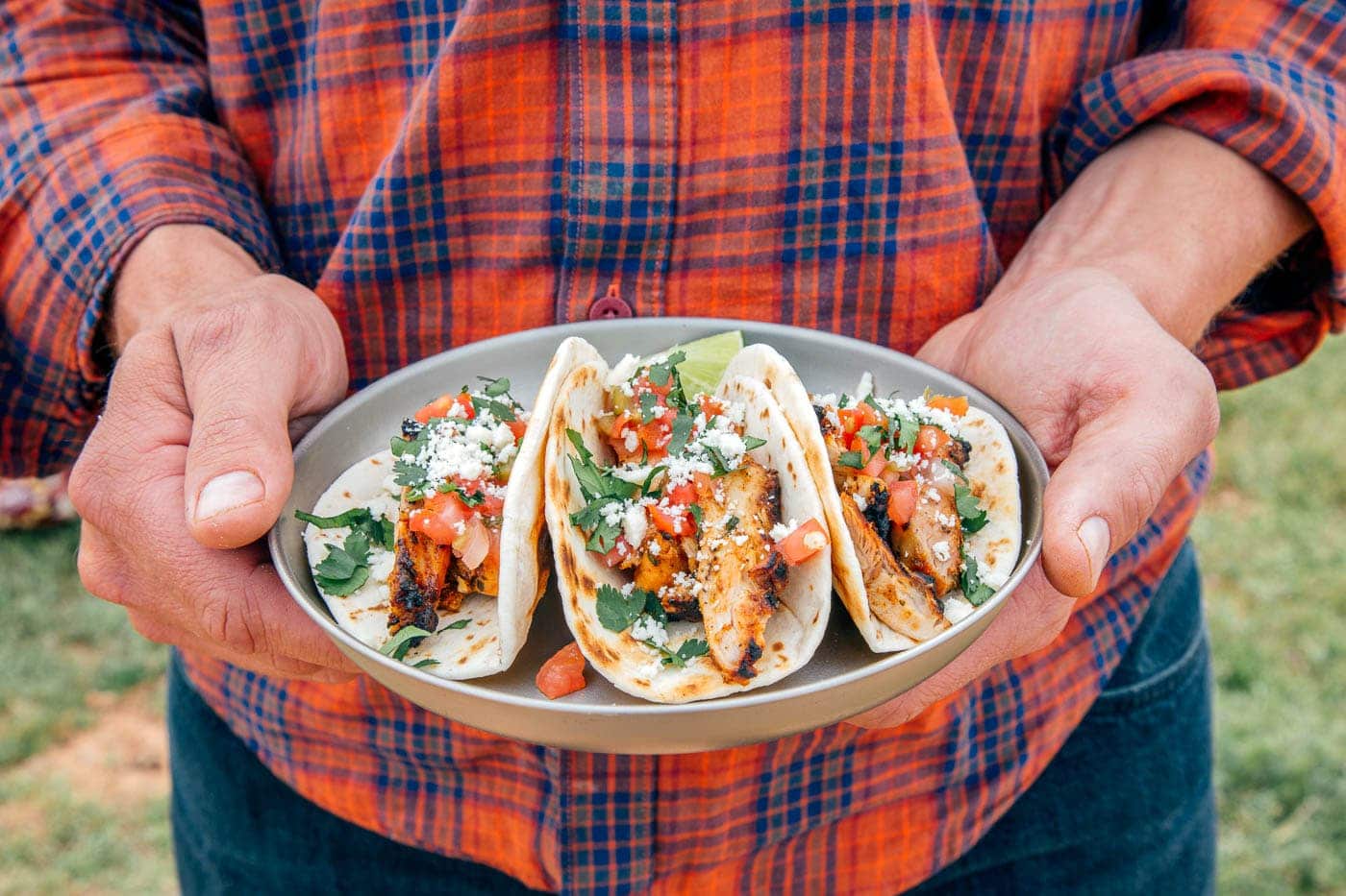 Michael holding a plate of grilled chicken tacos