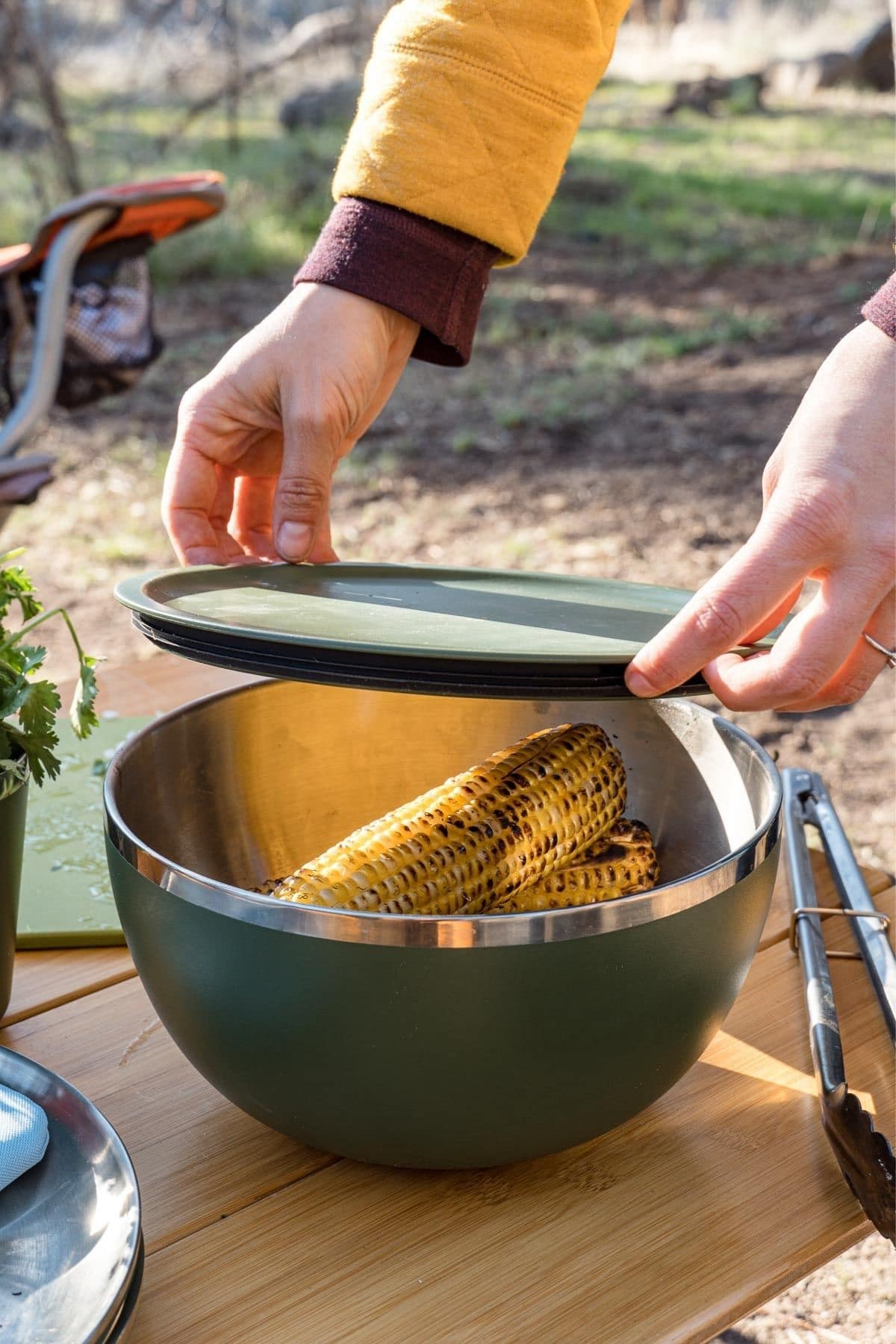 Megan putting a lid on top of a green insulated bowl