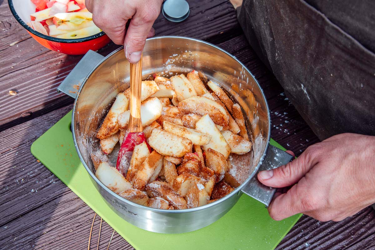 Mixing Dutch oven apple pie filling in a large bowl