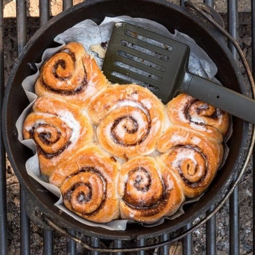 Cinnamon rolls in a dutch oven with a spatula