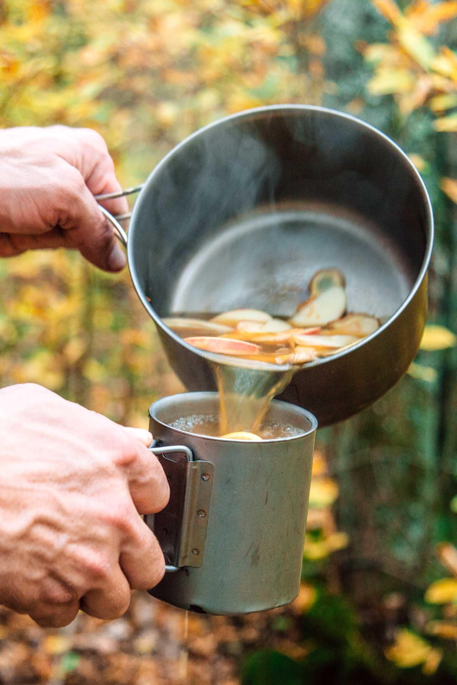 Michael pouring ginger apple cider from a pot into a mug