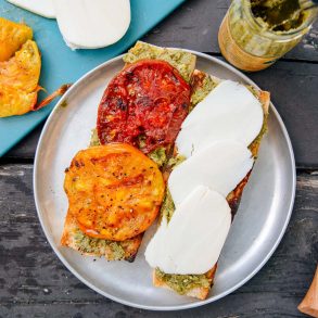 Grilled tomatoes and slices of cheese on a baguette