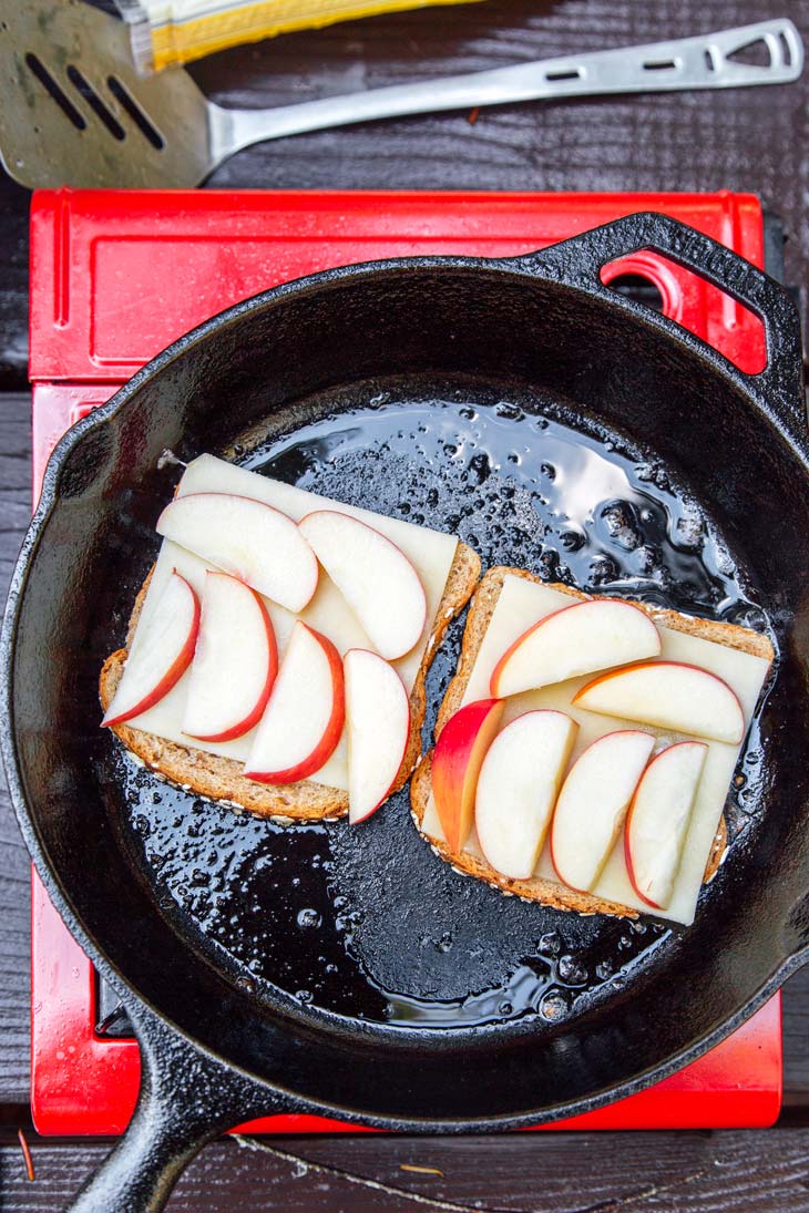 Bread layered with cheese and sliced apples in a skillet