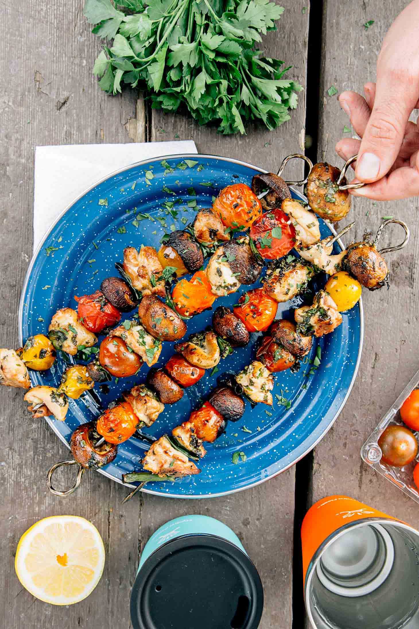 Grilled veggie & chicken skewers on a blue camping plate.