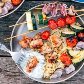 Chicken and vegetable skewers on a silver camping plate