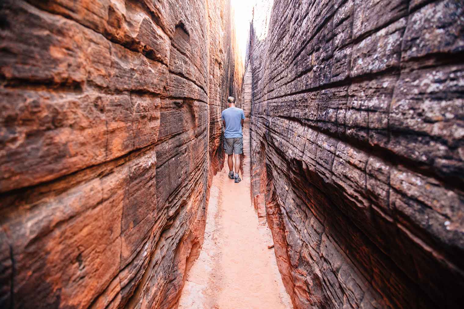 Michael walking through a slot canyon containing petroglyphs