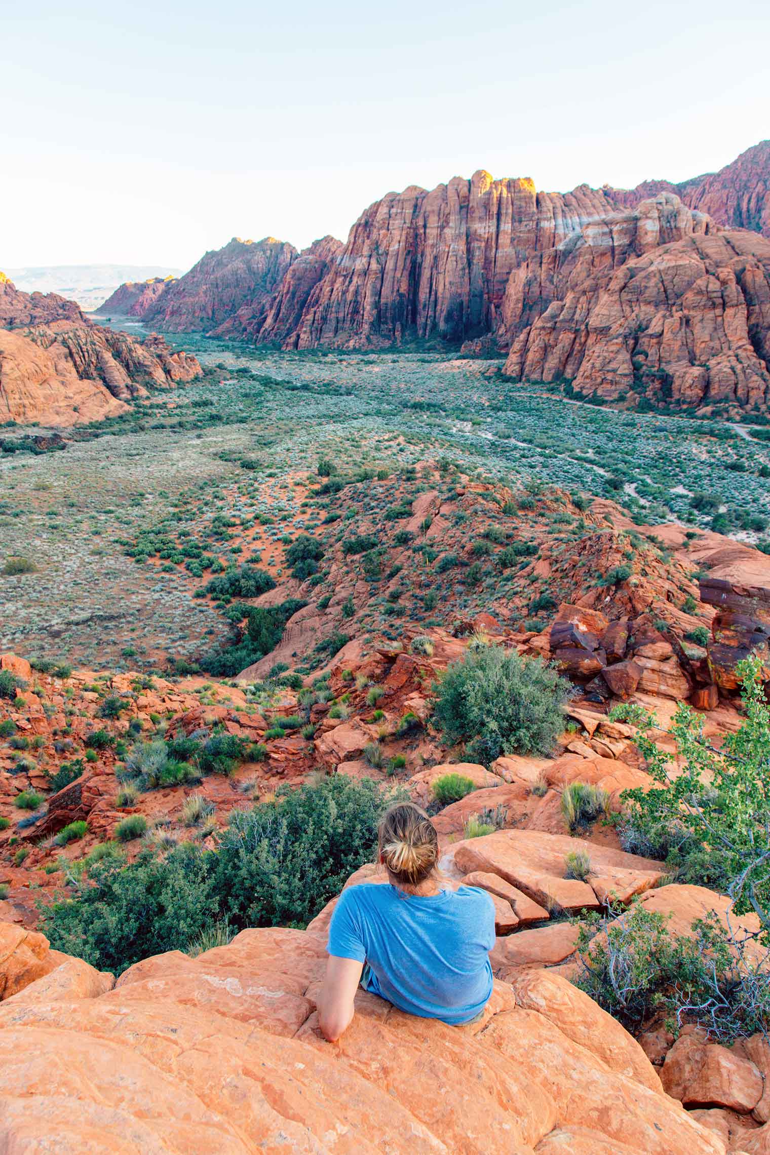 Michael relaxing on a tall rock outcropping overlooking snow canyon state park