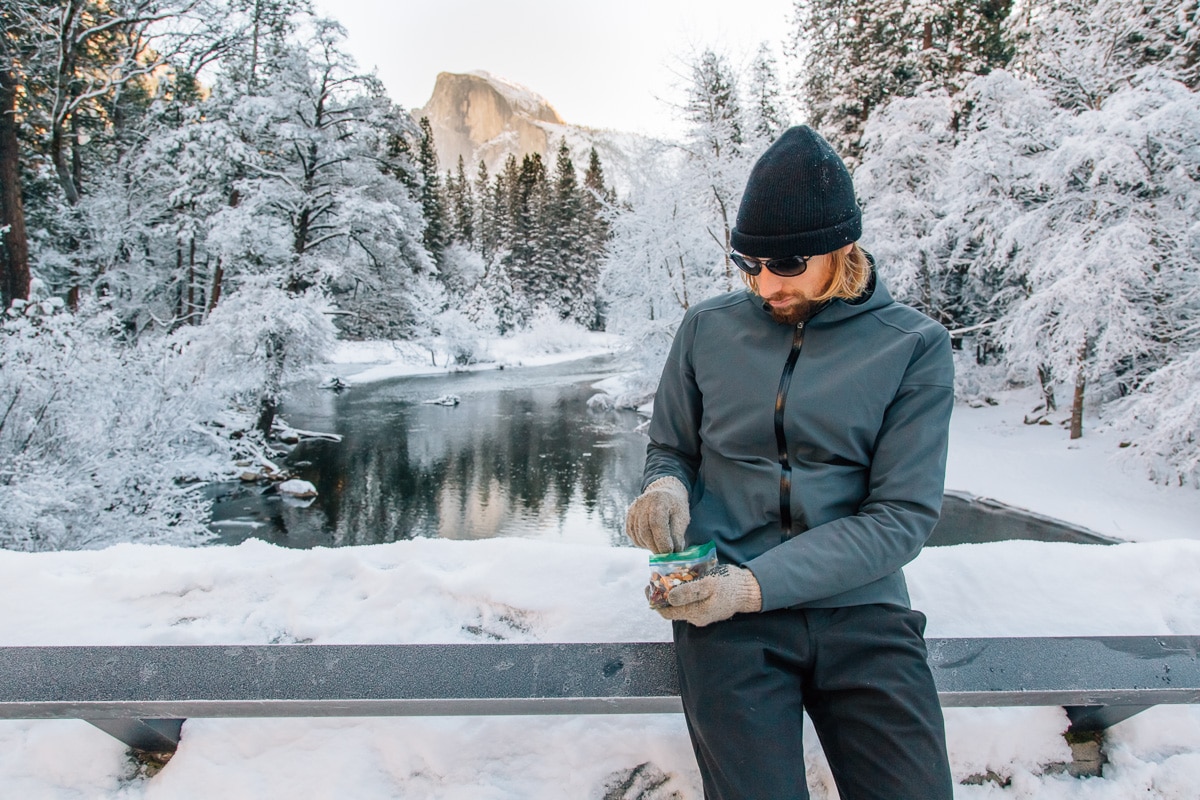 Michael standing on a bridge with a bag of trail mix