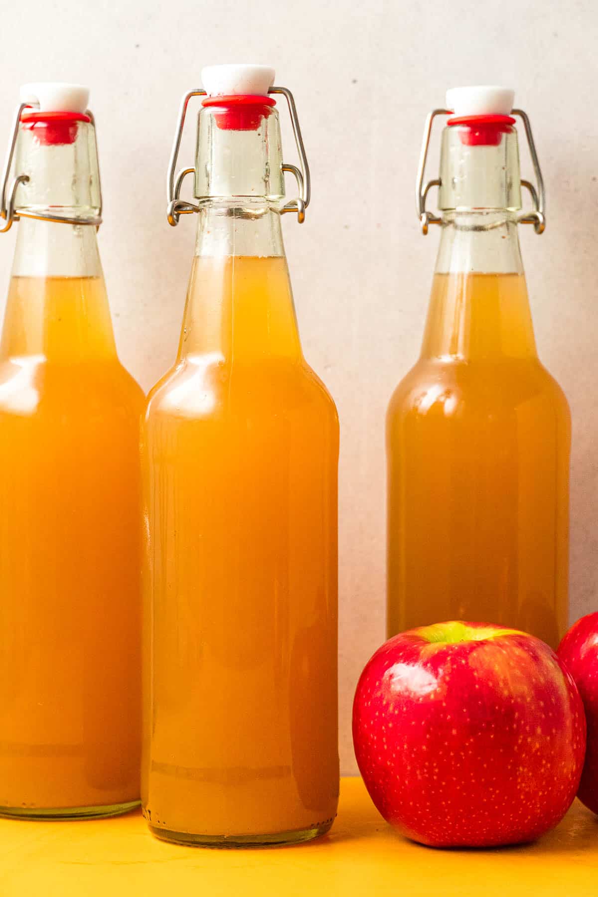 Three sealed bottles of homemade apple cider.