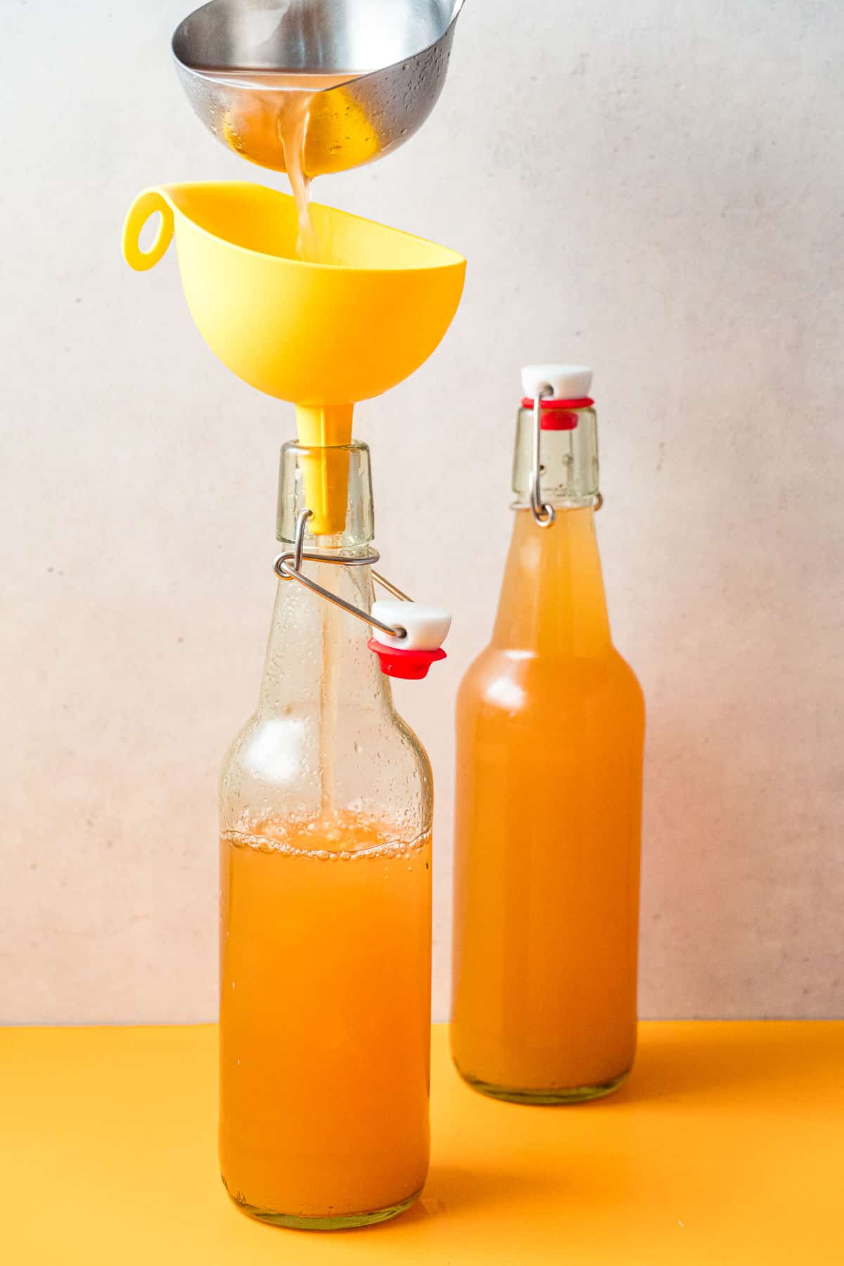 Using a funnel to transfer apple cider to bottles.