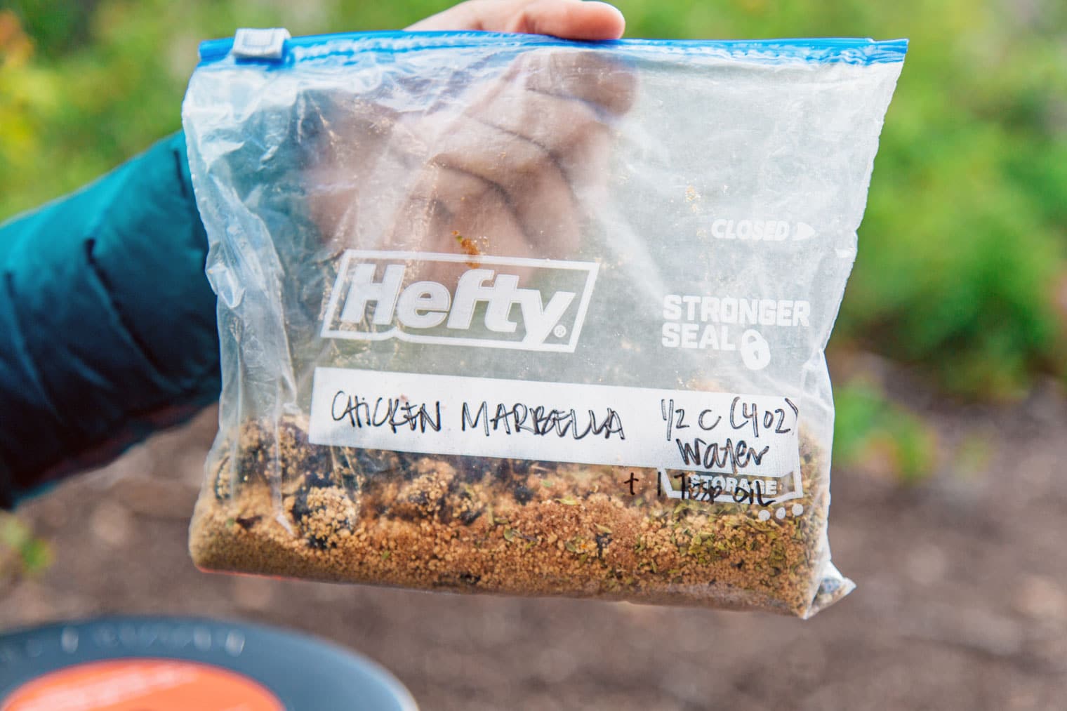 Megan is holding a Ziploc bag of ingredients labeled chicken Marbella