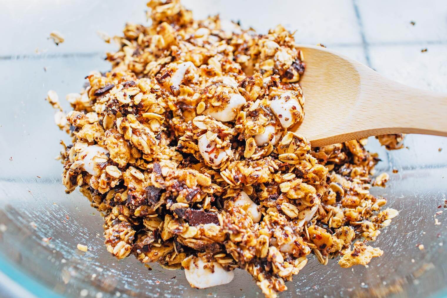 Spoon mixing ingredients for granola bars in a bowl