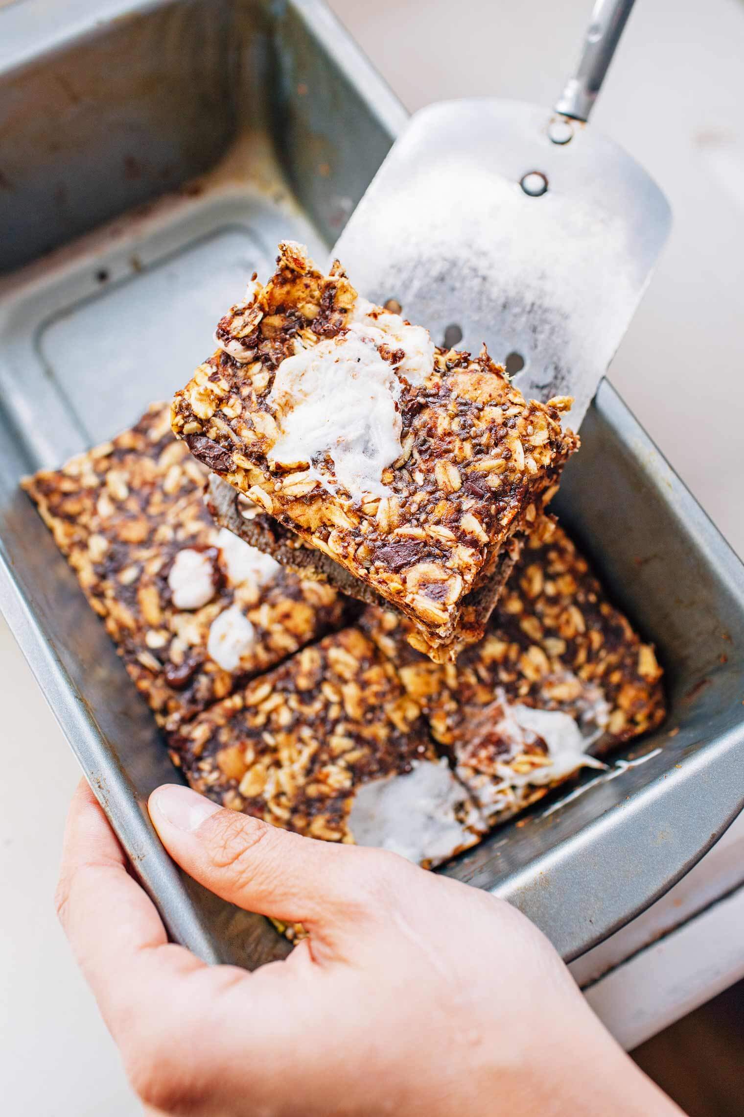 Michael using a spatula to lift a granola bar out of a baking pan