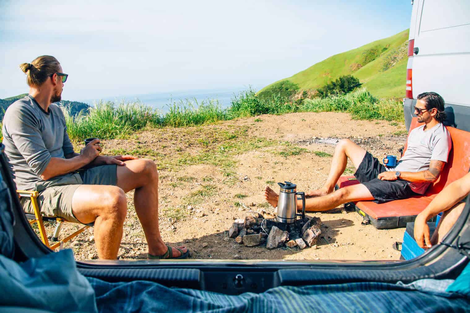 Two men sitting around a campfire in Big Sur