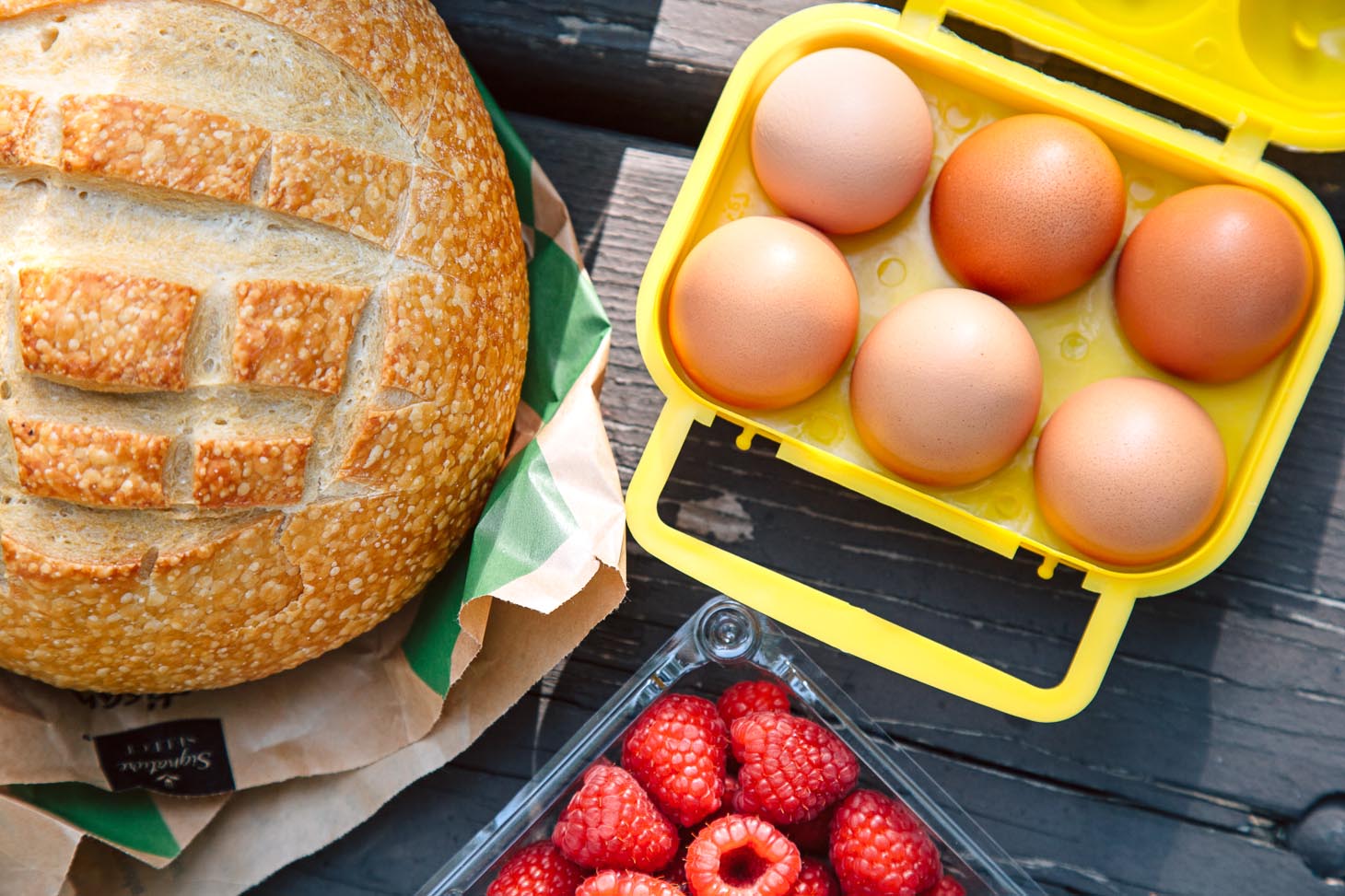 Ingredients for French toast including a loaf of bread and eggs in a yellow crate