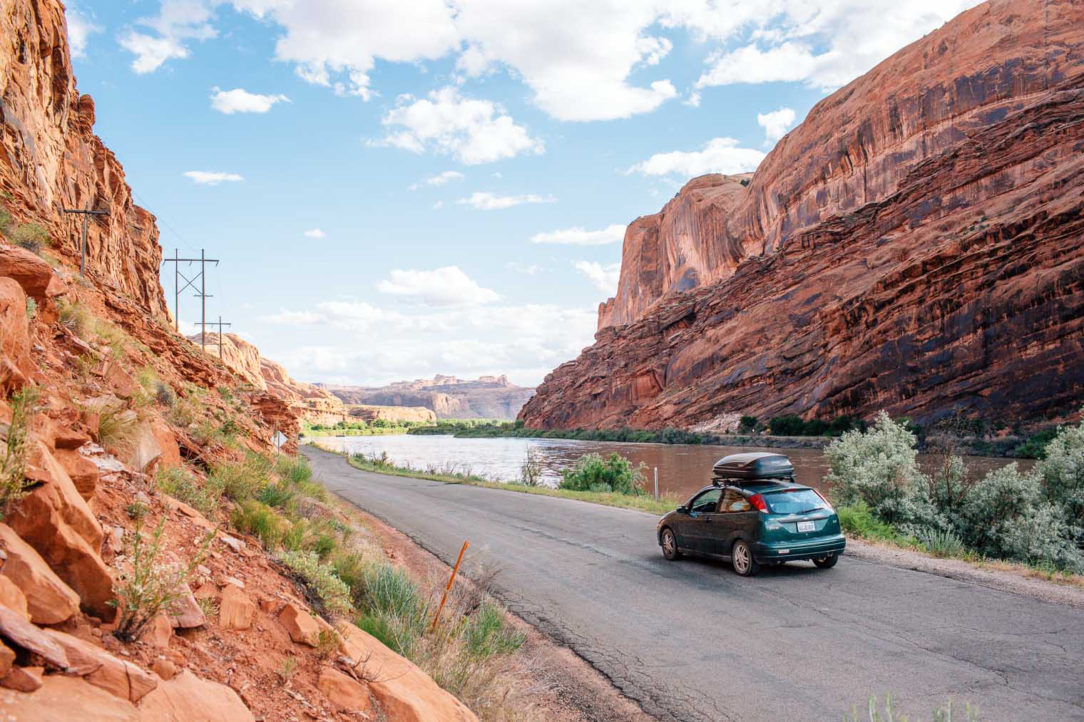 A green car driving on the Kane Creek scenic drive