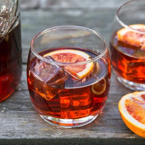 Negroni cocktail in a rocks glass on a wooden camping table.