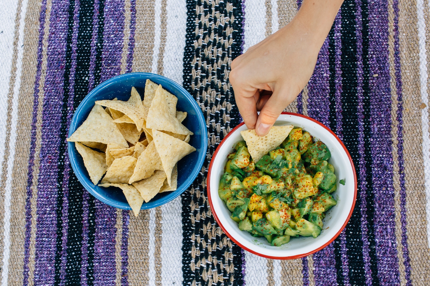 Megan using a tortilla chip to scoop up guacamole