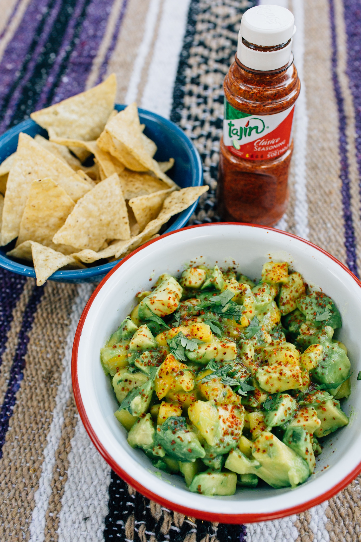 Mango guacamole in a red and white camping bowl