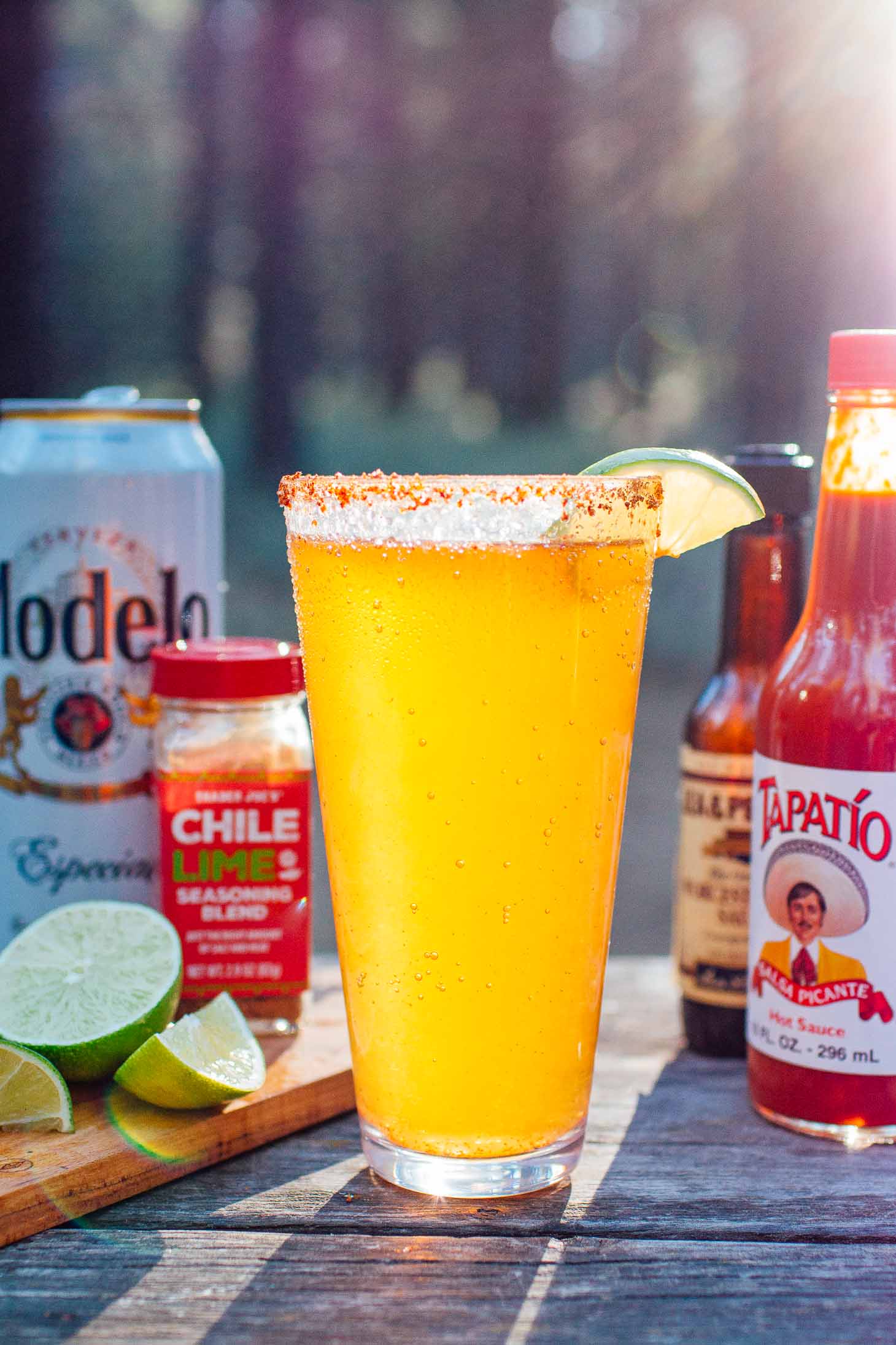 Michelada and ingredients with a forest background