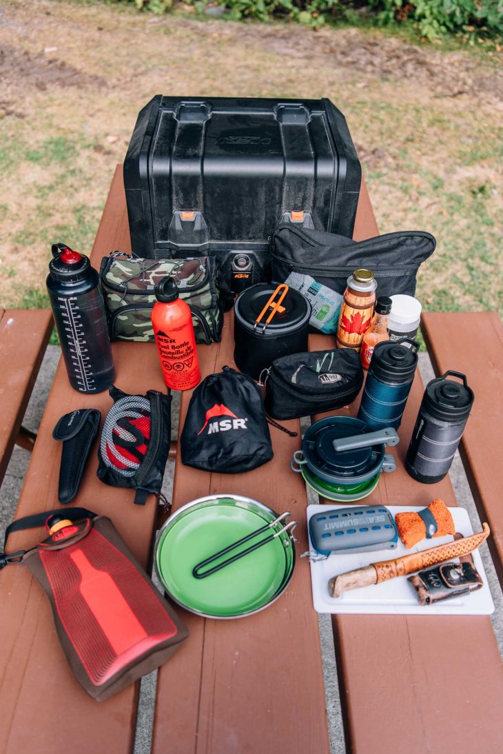Kitchen gear for motorcycle camping laid out on a picnic table