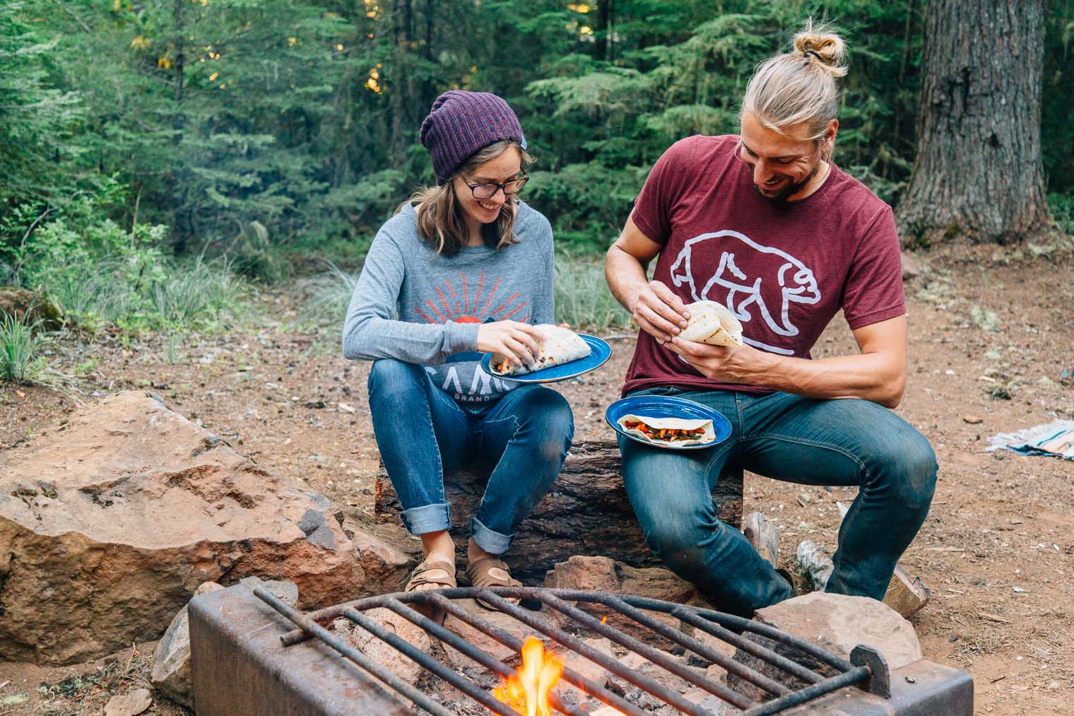 Megan and Michael eating dinner around a campfire