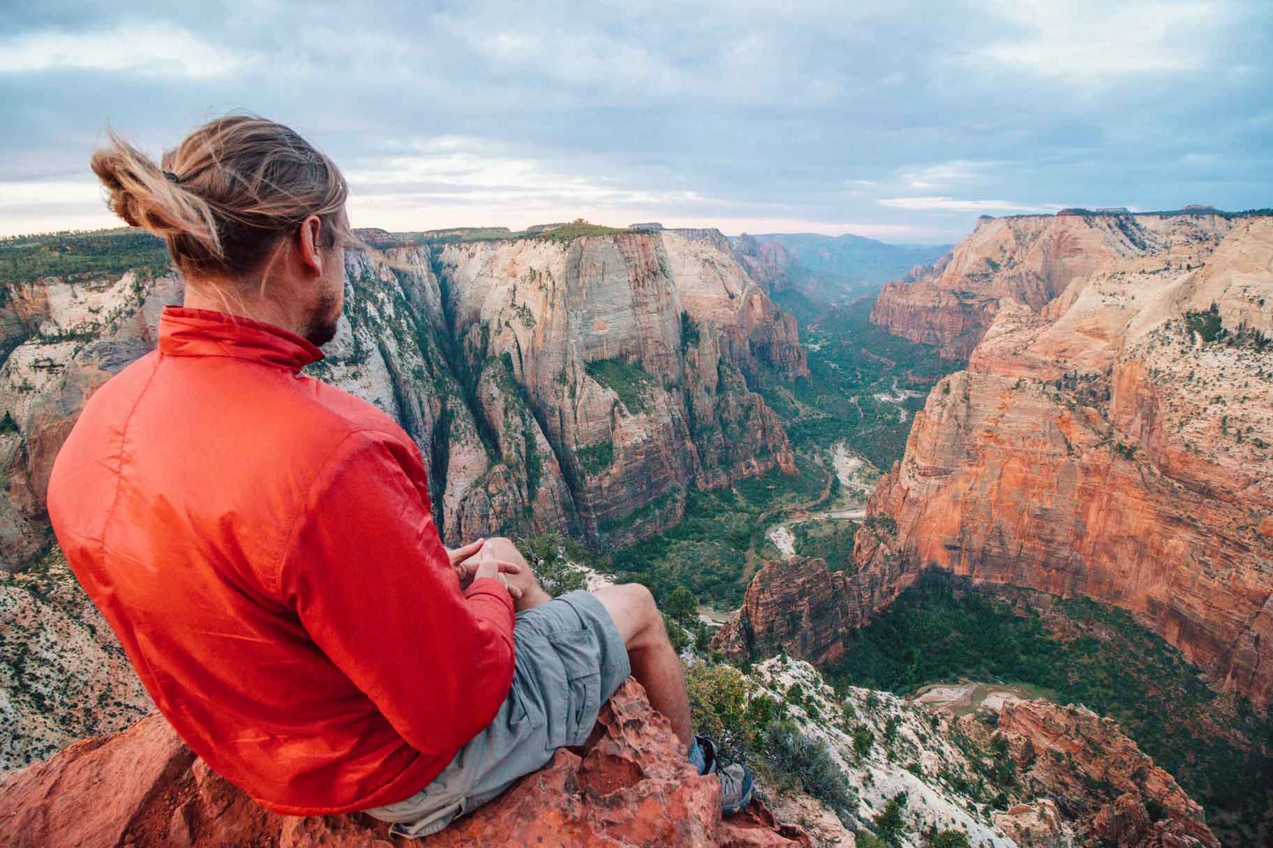 Michael sitting on a rock at observation point looking down into Zion Canyon