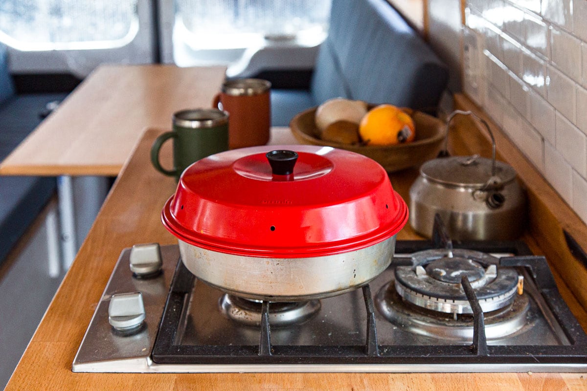 An Omnia oven on a stove burner in a campervan