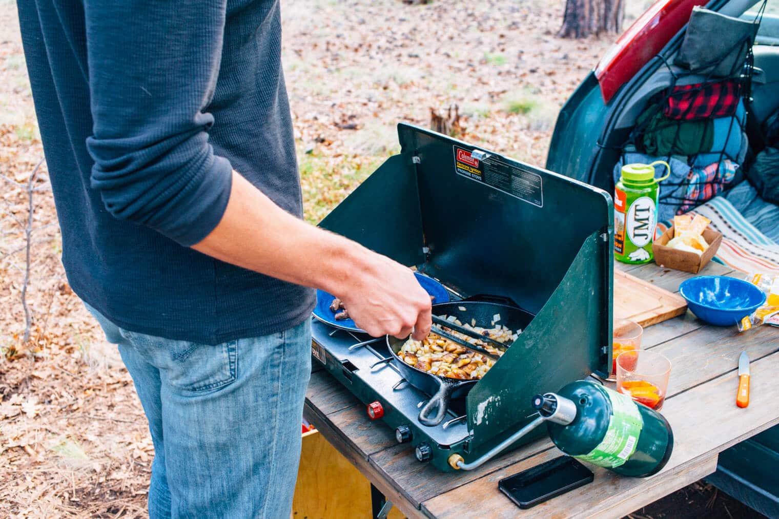 Michael cooking on a camping stove off of a tailgate