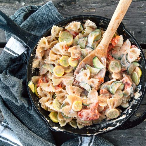 Pasta primavera in a cast iron skillet on a camping stove.