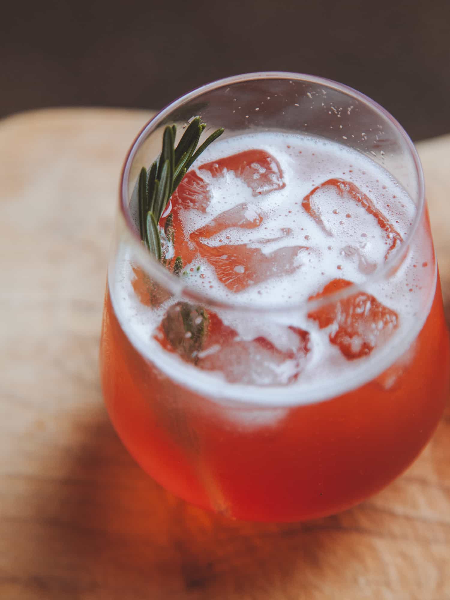 Plum Prosecco Spritz on a wooden background.