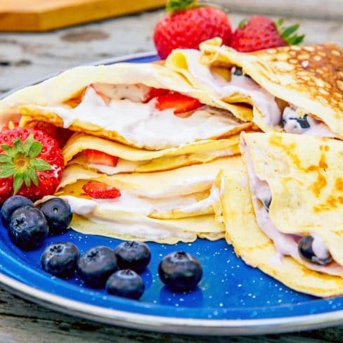 Icelandic pancakes filled with yogurt stacked on a blue plate